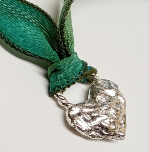 Judy Larson's Ribbon Wrapped Bracelet tips - , Wire Jewelry Design, Design,  heart shape, crafted from a textured, light silver-colored metal.